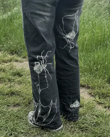 Jeans mit Spinnennetz-Motiv am Bein
